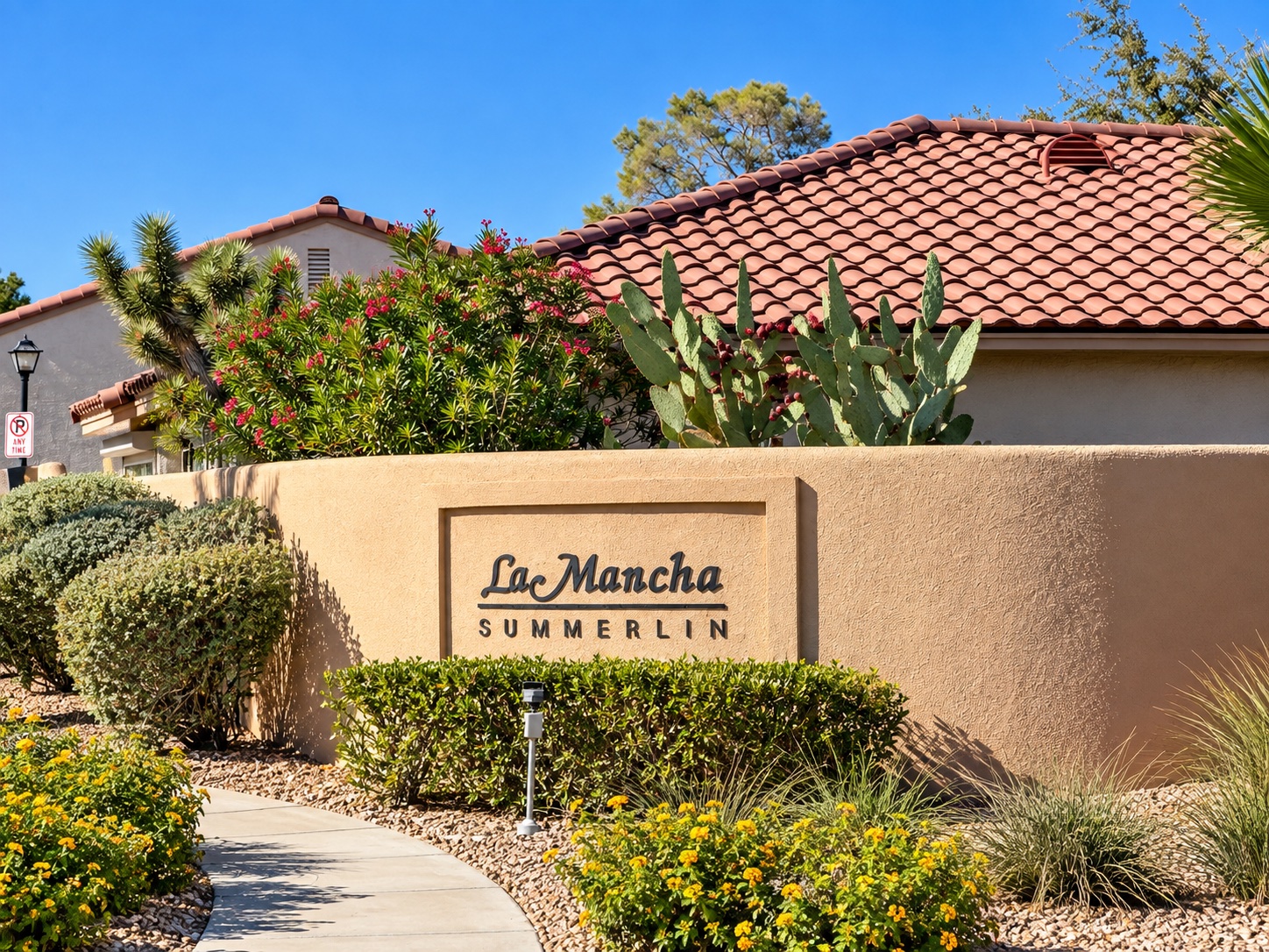 La Mancha Summerlin entrance sign with desert landscaping and tile-roof homes in The Pueblo, Las Vegas 89128