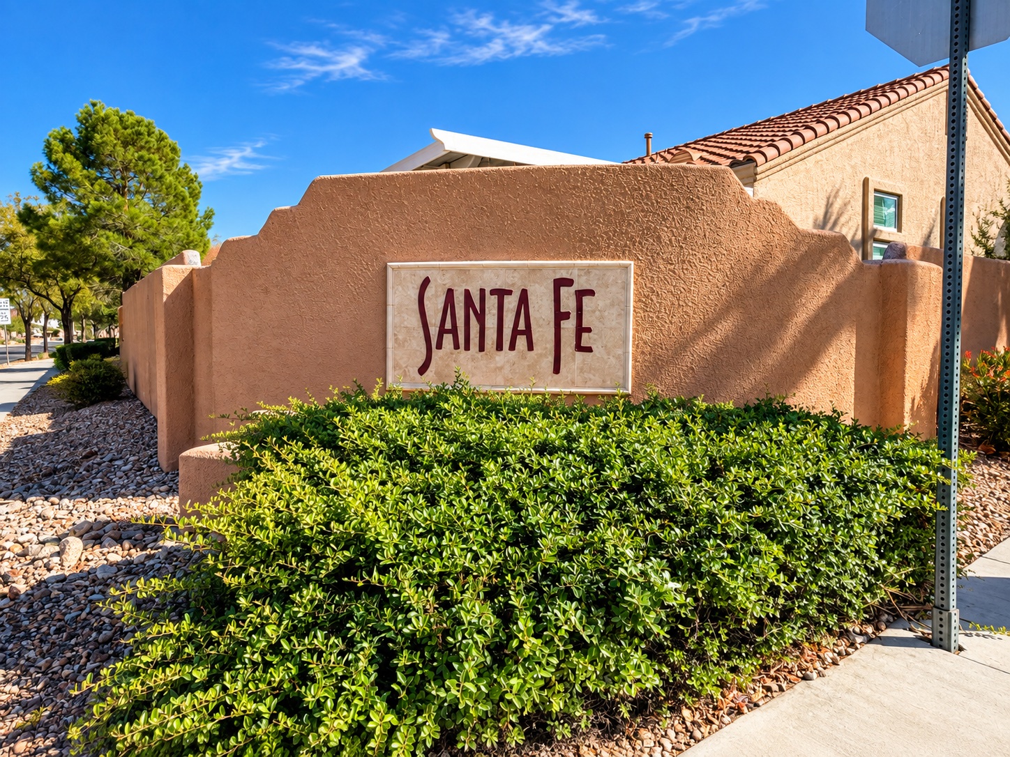 Santa Fe neighborhood entrance sign, desert landscaping, and tile-roof home in The Pueblo, Summerlin, Las Vegas 89128