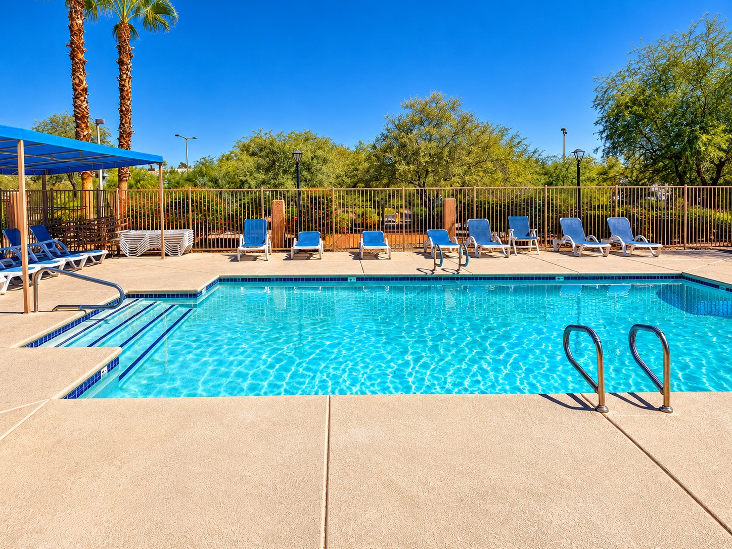 Buena Vista community swimming pool with blue lounge chairs and shaded seating in The Pueblo, Summerlin, Las Vegas