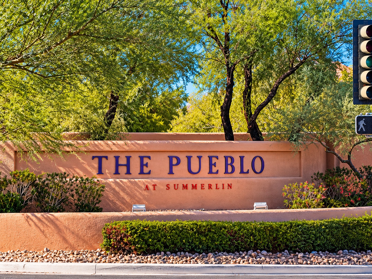 The Pueblo at Summerlin entrance sign surrounded by mature trees and desert landscaping in Las Vegas, Nevada 89128